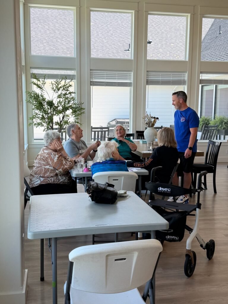 Residents gathered around a table with a staff member during an activity at The Ponderosa Estate