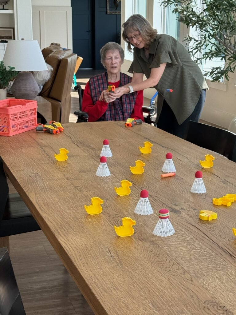 A staff member helping a Resident enjoy an activity at The Ponderosa Estate