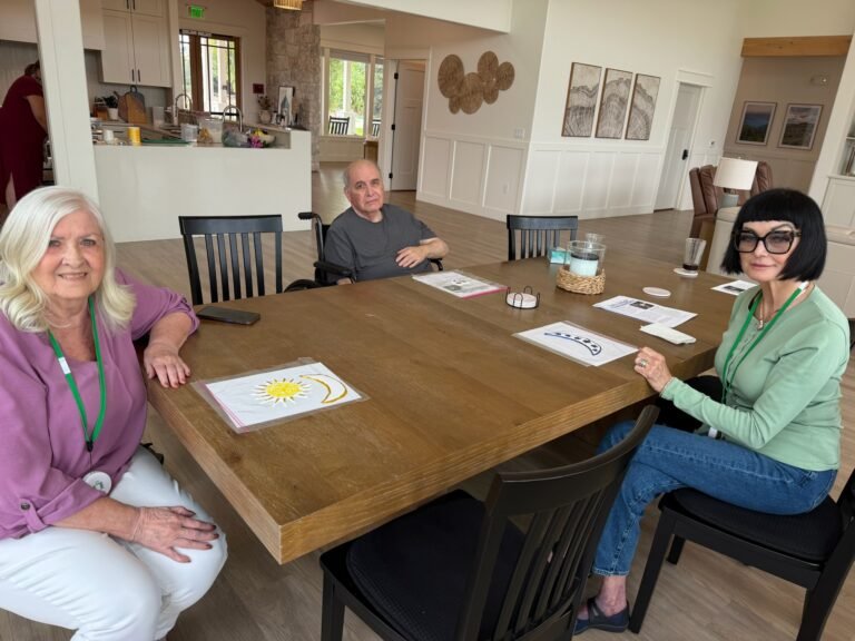 Siblings and residents gathered around a table at The Ponderosa Estate discussing an assisted living care decision