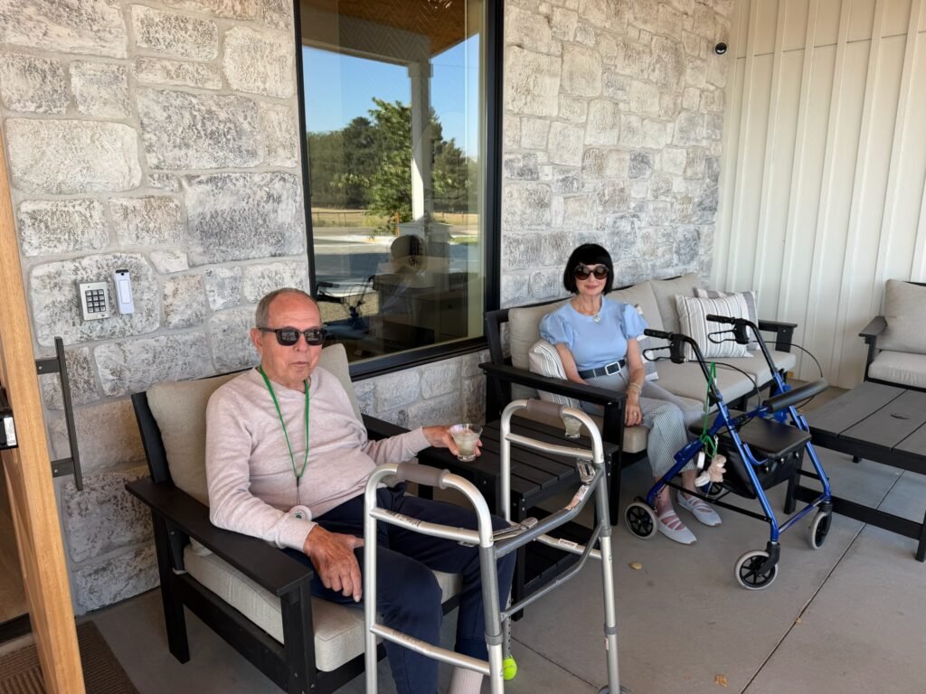 Two Residents relaxing on the porch with their mobility walkers at The Ponderosa Estate