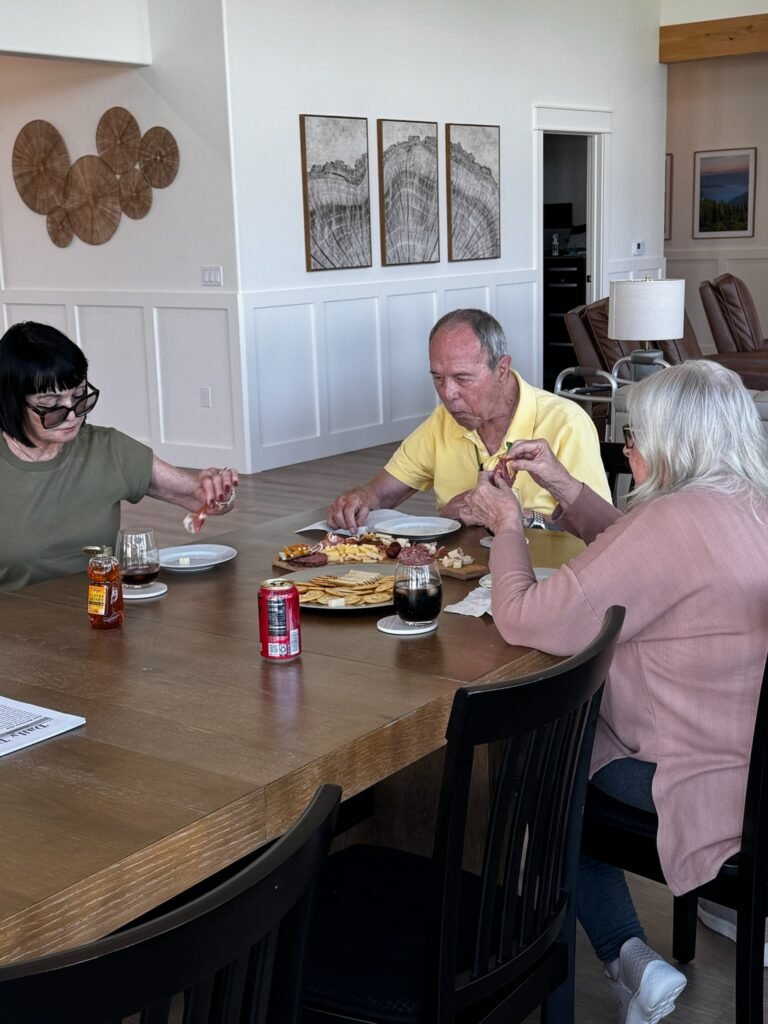 Residents enjoying a charcuterie board together at the dining table at The Ponderosa Estate