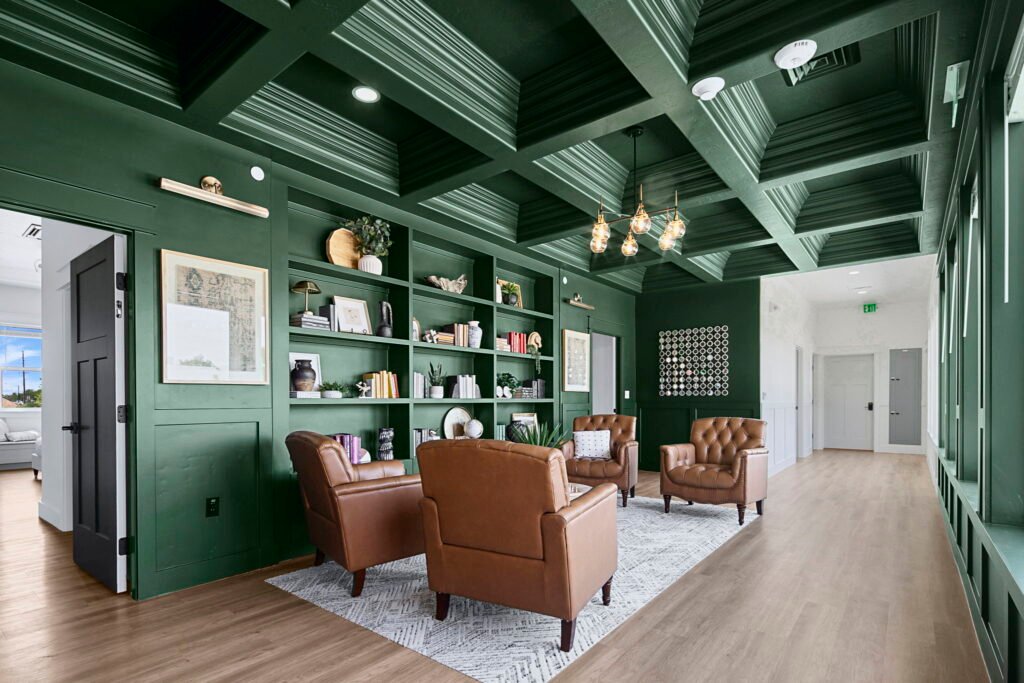 Leather armchairs and built-in bookshelves in the forest green library lounge at The Ponderosa Estate in Eagle, Idaho