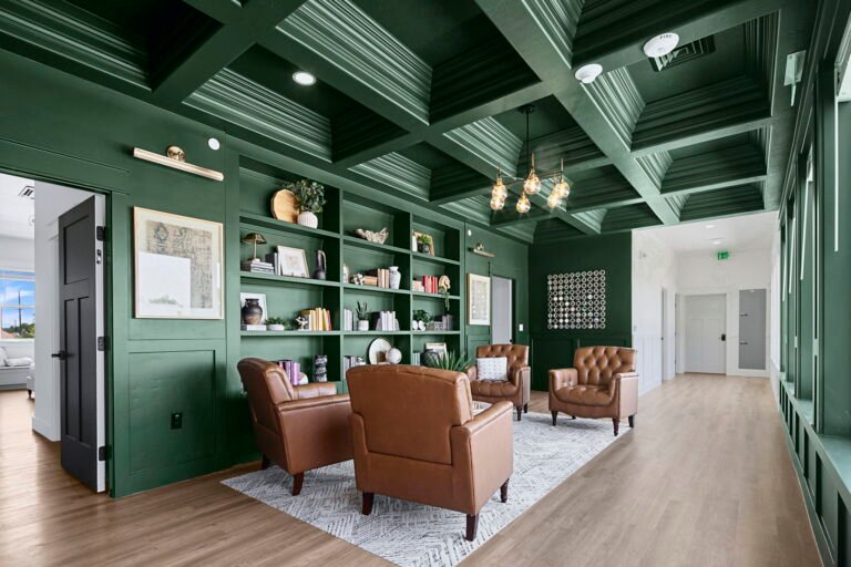 Leather armchairs and built-in bookshelves in the forest green library lounge at The Ponderosa Estate in Eagle, Idaho