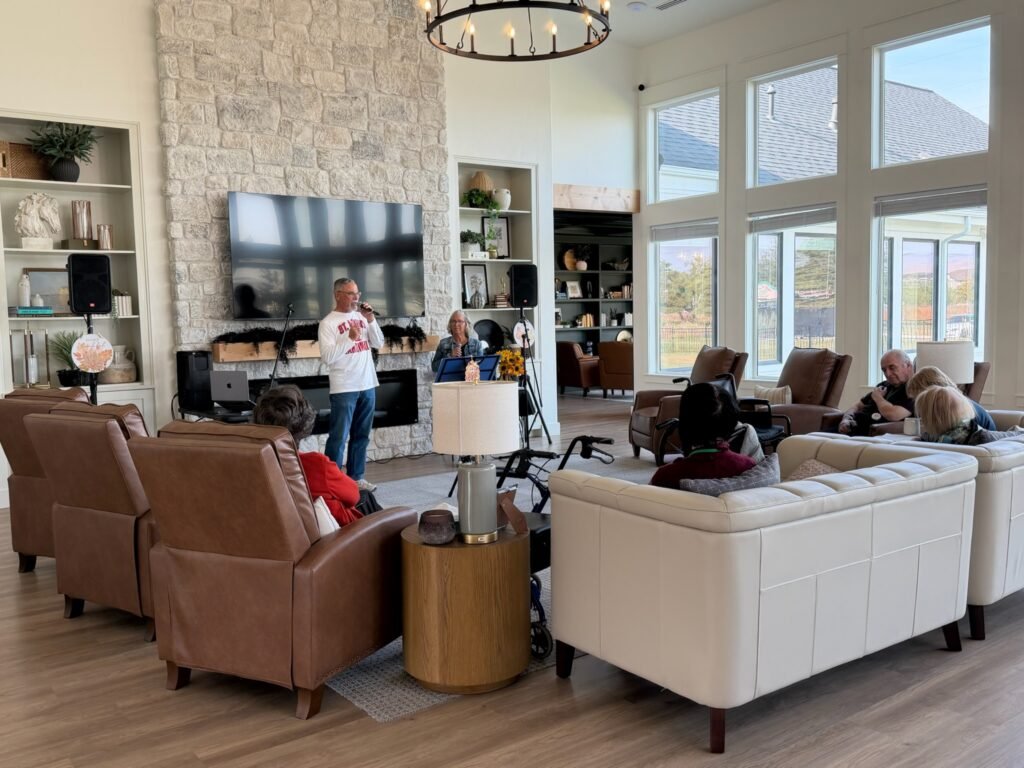 Residents enjoying a live music performance by the stone fireplace in the great room at The Ponderosa Estate in Eagle, Idaho