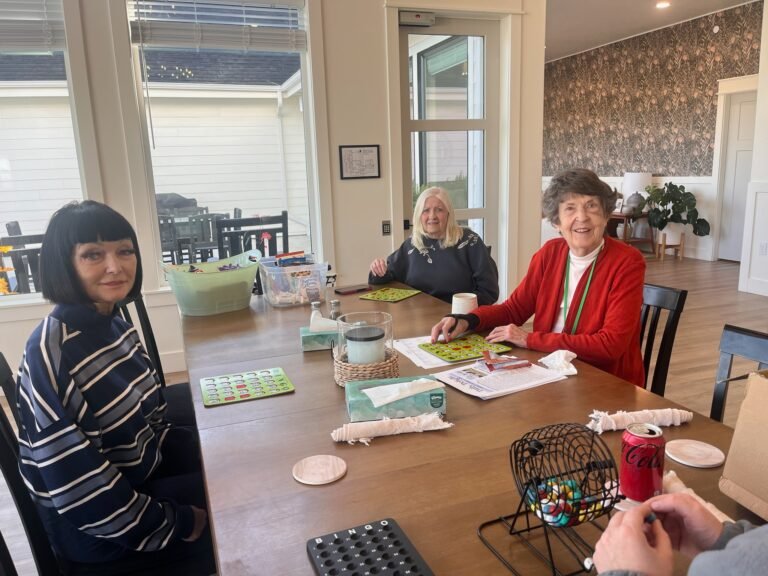 Residents enjoying a game of bingo together in the sunlit dining room at The Ponderosa Estate in Eagle, Idaho